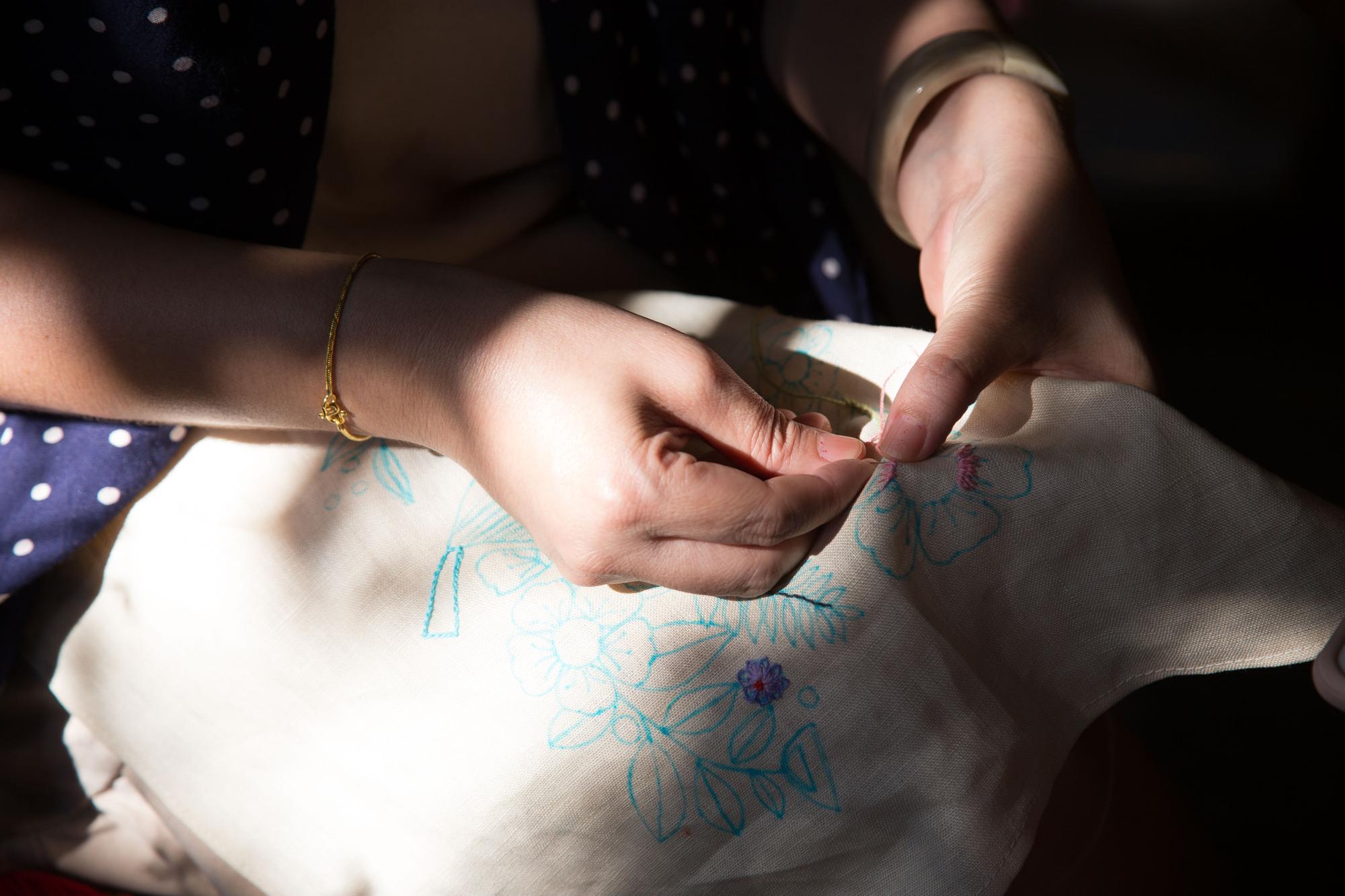 Hand embroiderer working on detailed motif